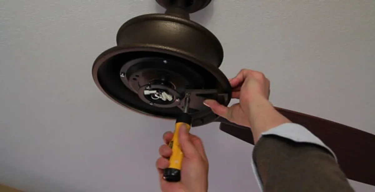 Electrician installing ceiling fan mounting bracket and fixture in Las Vegas, NV